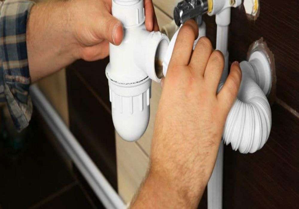 Licensed plumber inspecting kitchen plumbing system